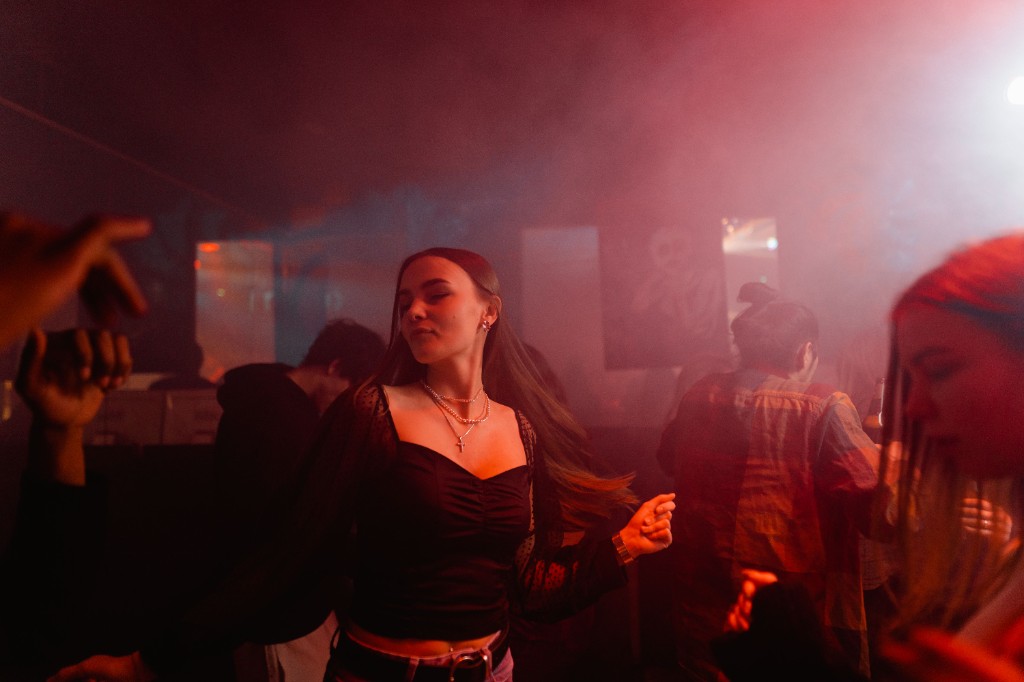 A guest dancing in red club lighting at a party